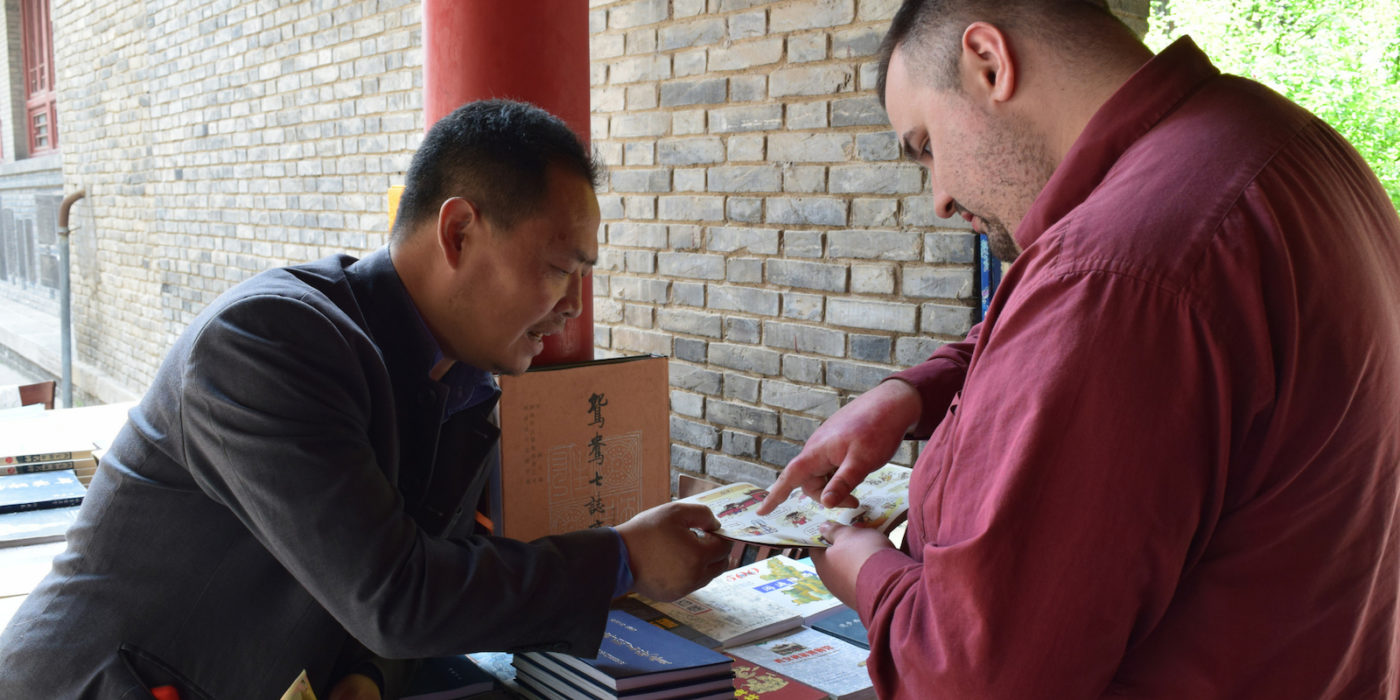 A student talking to a Chinese bookseller