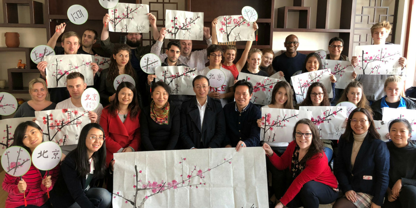 Group of students holding up their Chinese calligraphy work