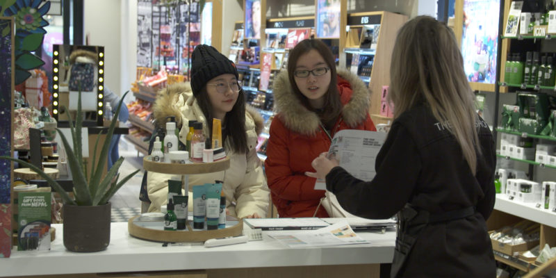 A Body Shop staff member talking to two Chinese customers
