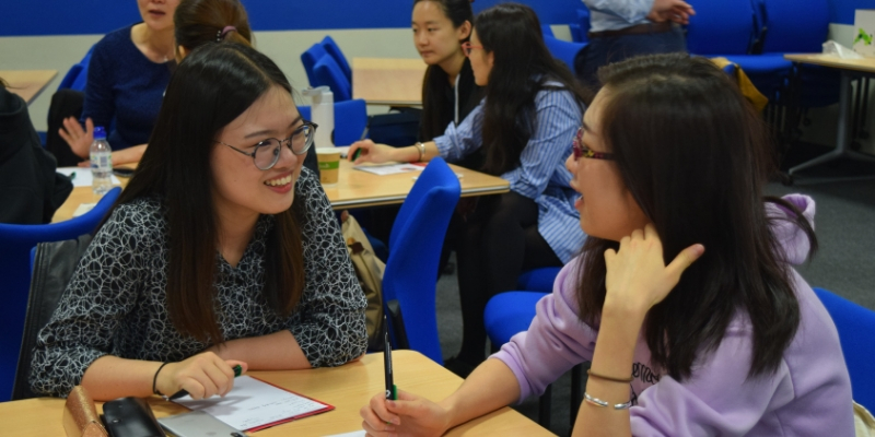 Two Chinese attendees in discussion at a previous teacher training event
