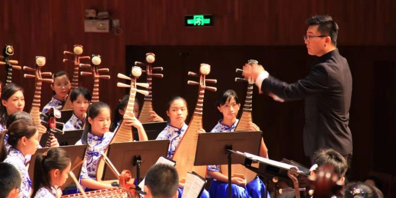 Traditional Chinese orchestra and conductor on stage performing