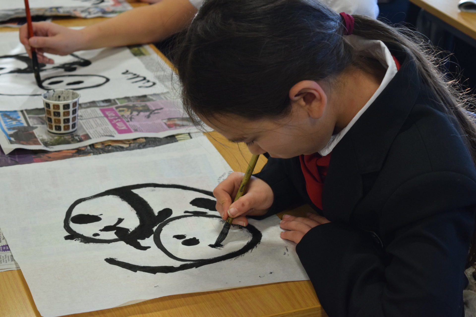 School student painting a panda
