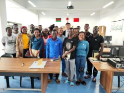 Group photo in a classroom shows Xiaolong with his African students