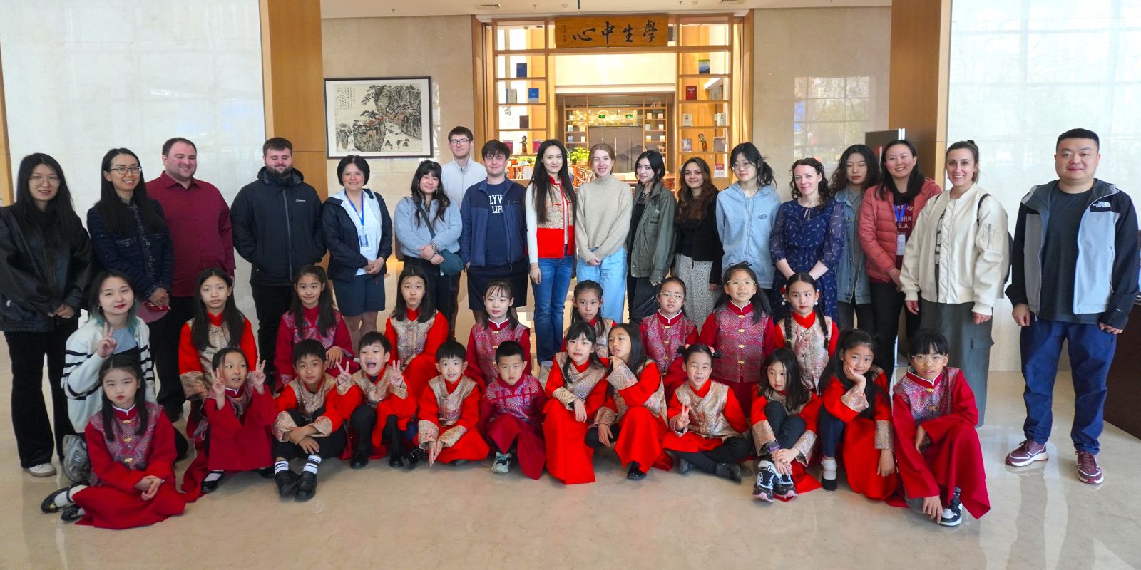 Group photo shows the China Camp group behind Chinese school children dressed in red